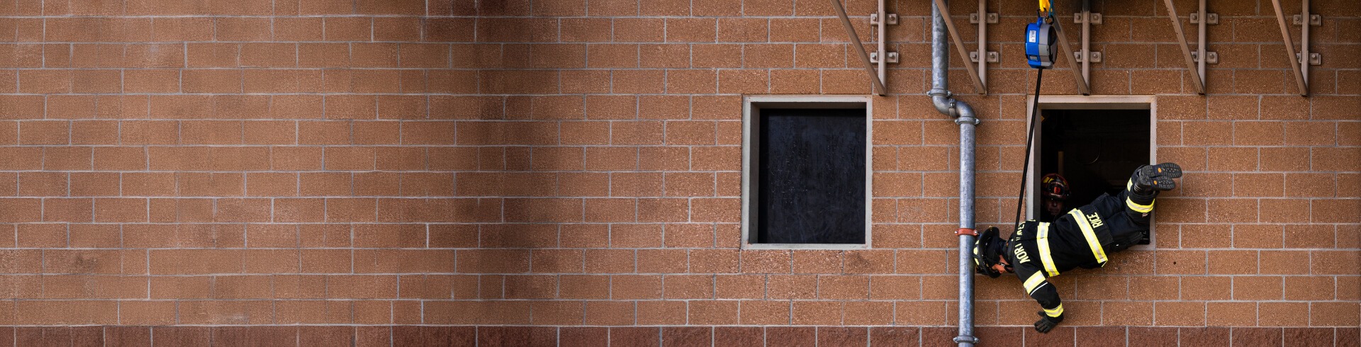 Firefighter performing a window bailout using TruBlue SafeLine during training