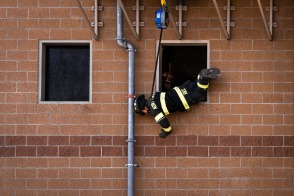 Firefighter executing a window bailout with TruBlue SafeLine in a training scenario
