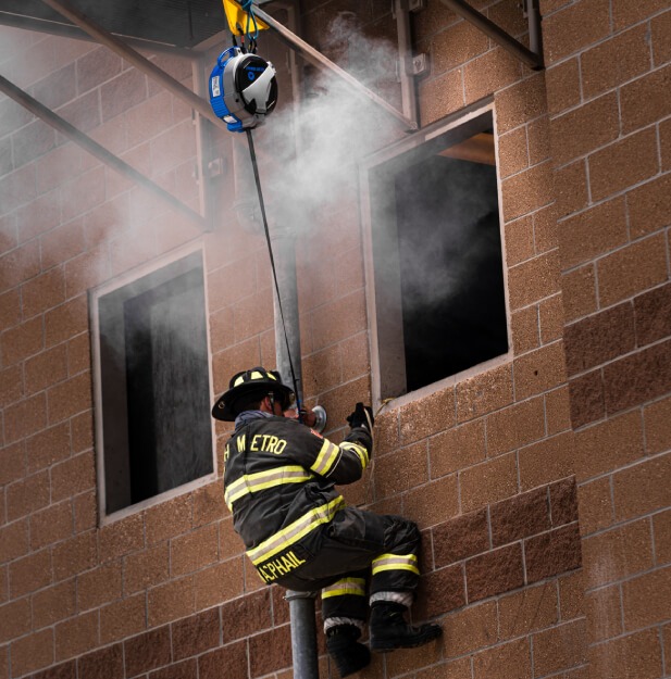Firefighter descending from a window using TruBlue SafeLine during training